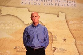 How long did Rick Scott serve in the Navy?